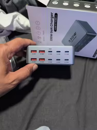 PowerNorth 330W GaN charger held in hand next to its retail box